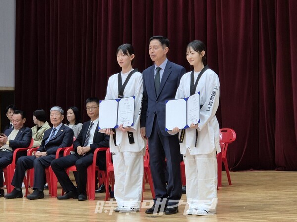 장학증서를 전달하고 충청북도 태권도협호 송석중회장과 기념촬영을 하는 좌측 신은영, 우측정가은 선수 (사진_이성만 기자)